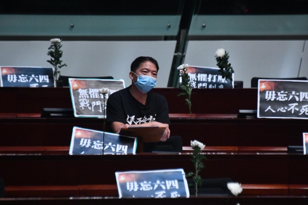 民主派議員在桌面擺上白花和悼念標語。