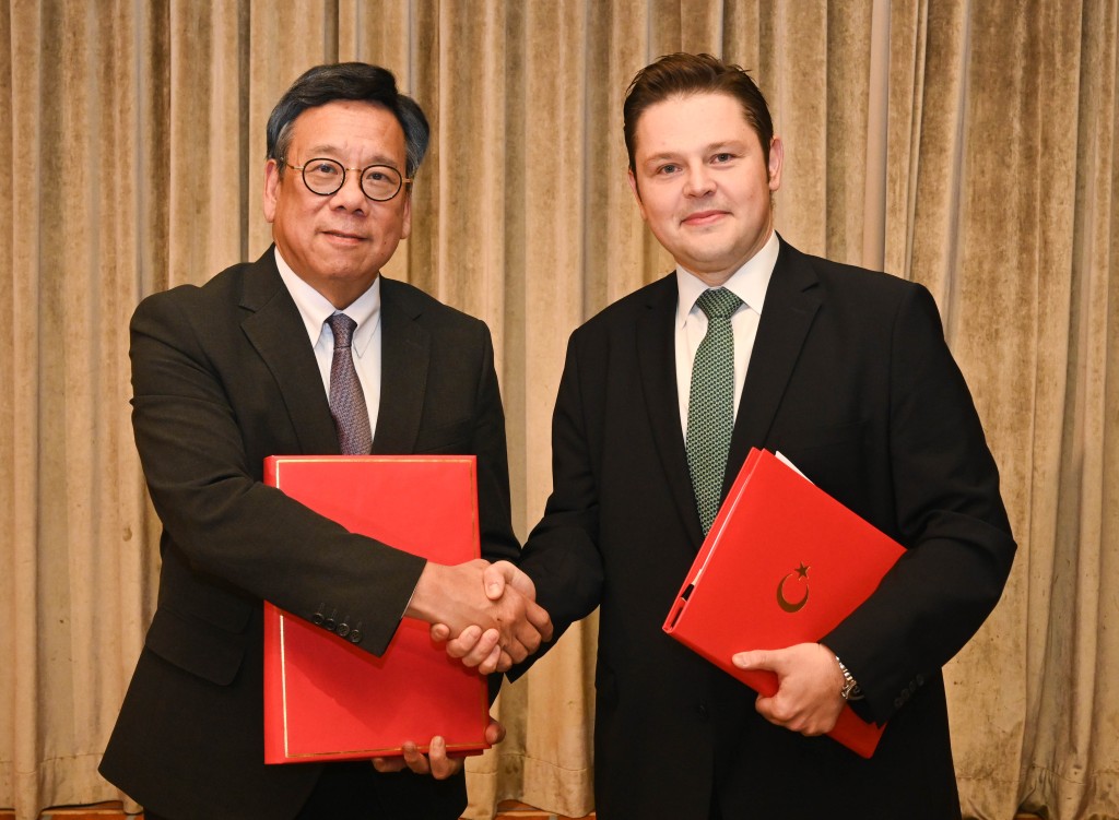 丘應樺（左）與土耳其駐港總領事Kerim Sercan Evcin（右）交換已簽署的投資協定文件。