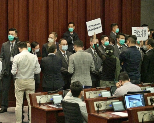 民主派議員舉起寫有「濫權」的標語。
