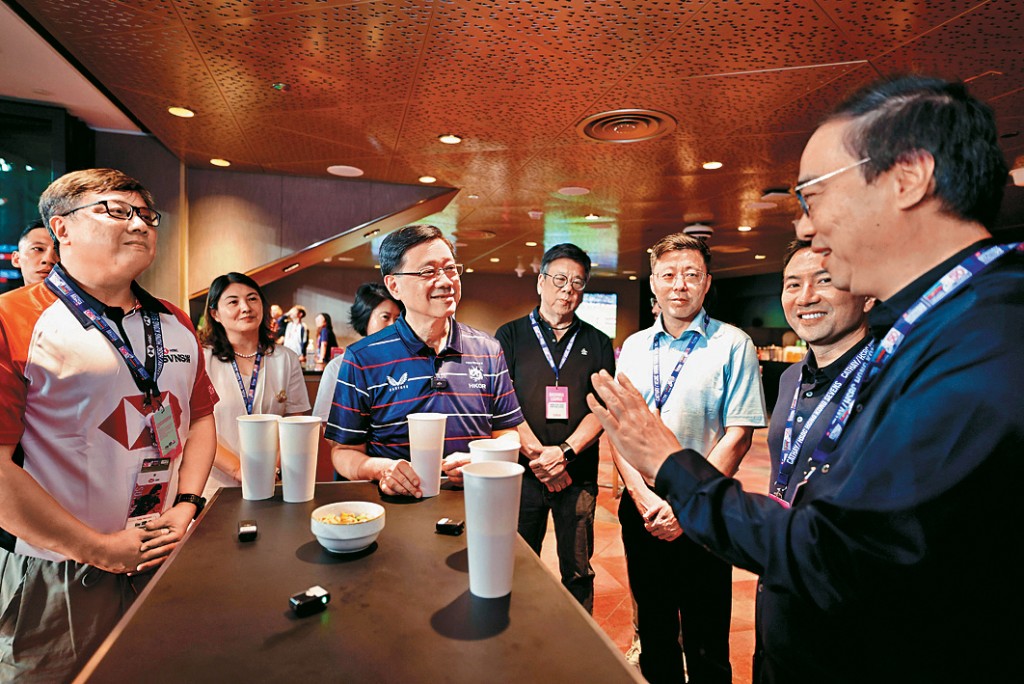 李家超在比賽期間，跟香港華為國際有限公司行政總裁陳建韓、中國移動國際董事長王華等人傾談。