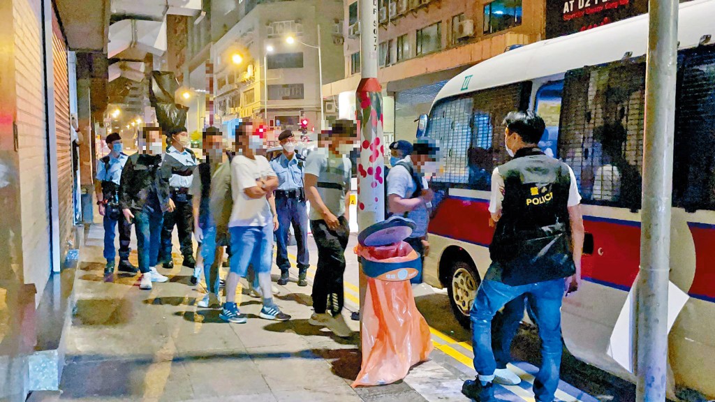 警方將身處無牌酒吧男女顧客帶署調查。 