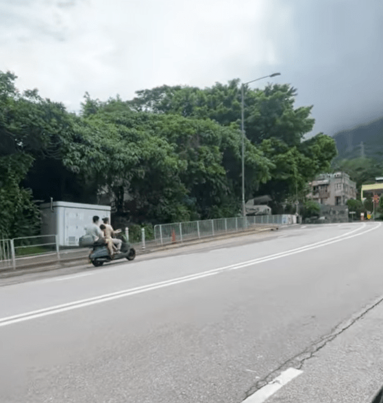 一家三口电单车疾驶马路上。网片截图