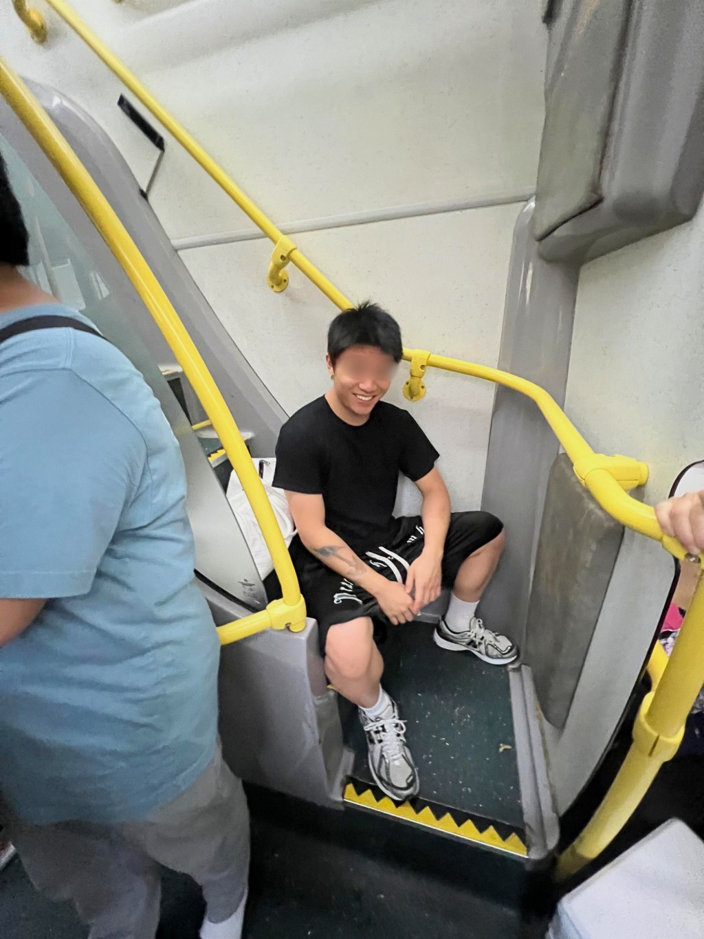 紋身青年阻礙乘客登上上層後,還露出一臉得意的挑釁笑容。(來源:Threads) 紋身青年阻礙乘客登上上層後,還露出一臉得意的挑釁笑容。(來源:Threads)