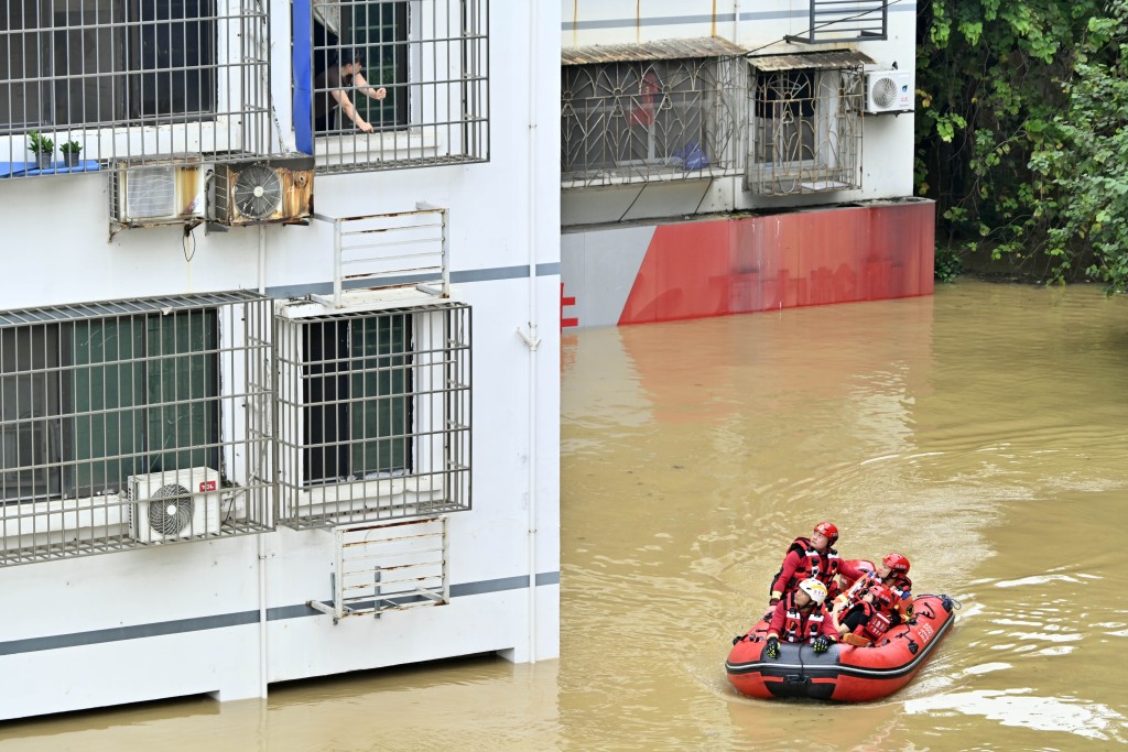 救援人員乘橡皮艇穿行街道。（中新社）