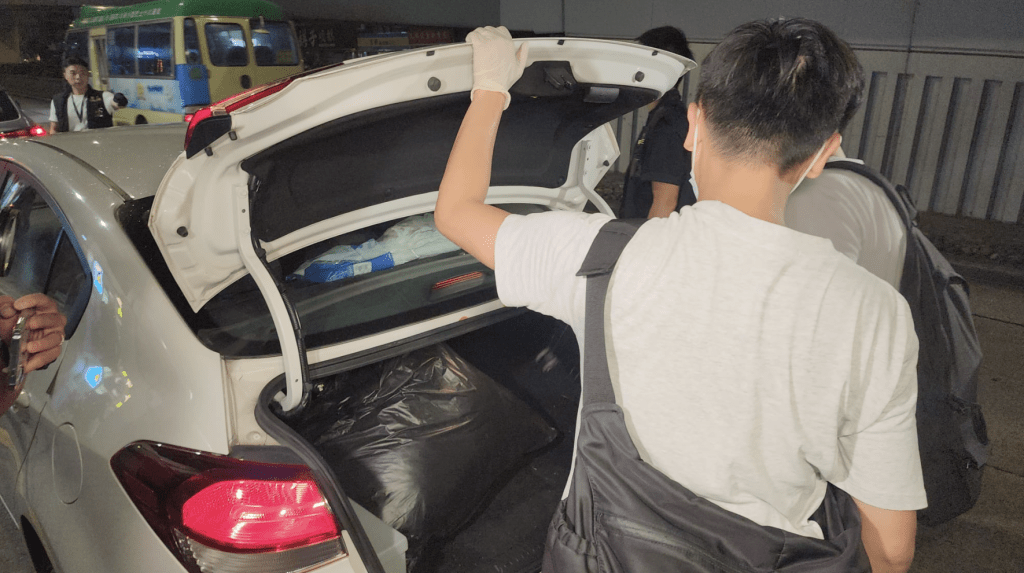 警方晚上從案發單位取走多袋證物。黎志偉攝 警方晚上從案發單位取走多袋證物。黎志偉攝