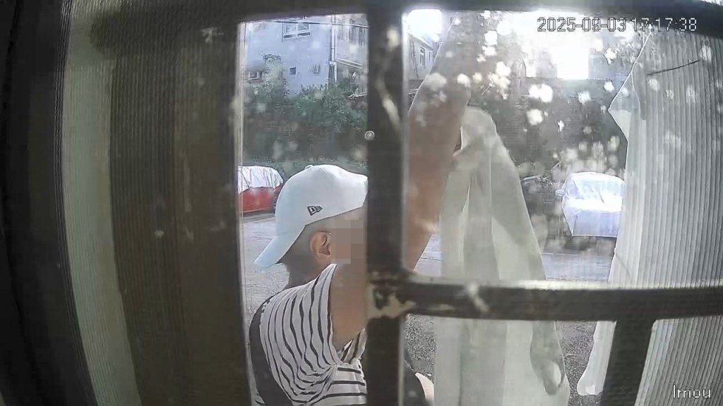 一名身穿間條上衣的男子偷走掛在屋外的一件衫及一條褲。FB「錦上路之友」片段截圖 一名身穿間條上衣的男子偷走掛在屋外的一件衫及一條褲。FB「錦上路之友」片段截圖
