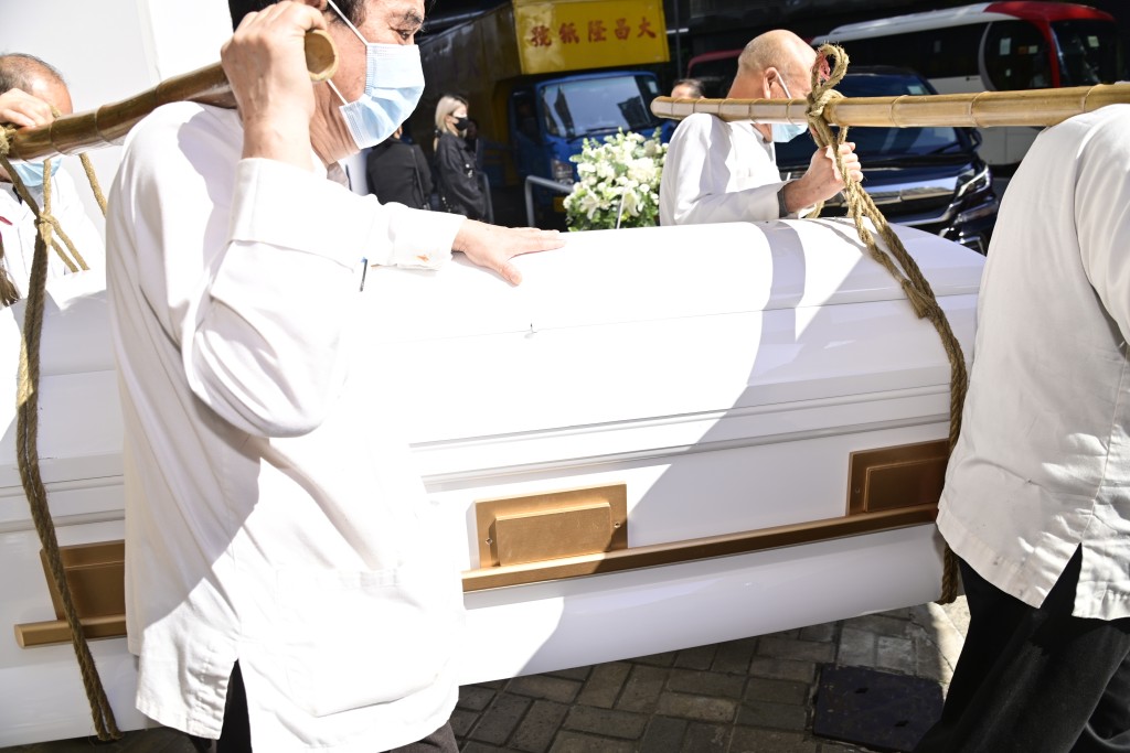 黎淑贤的白色棺木由工作人员移上灵车。