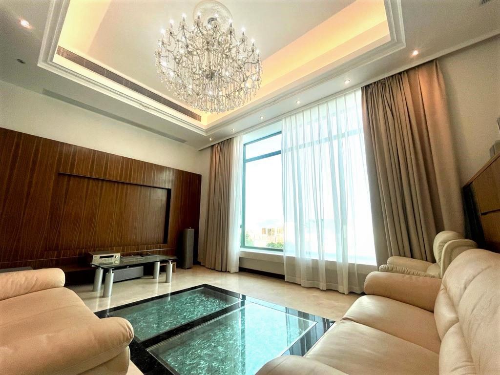 客廳採吊燈配合胡桃木特色牆設計，呈現出低調高雅的氣派。