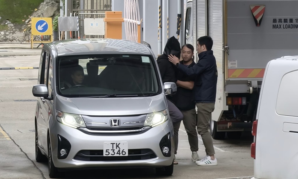 探員押解黑布蒙頭的「左口」。曾志恆攝 探員押解黑布蒙頭的「左口」。曾志恆攝