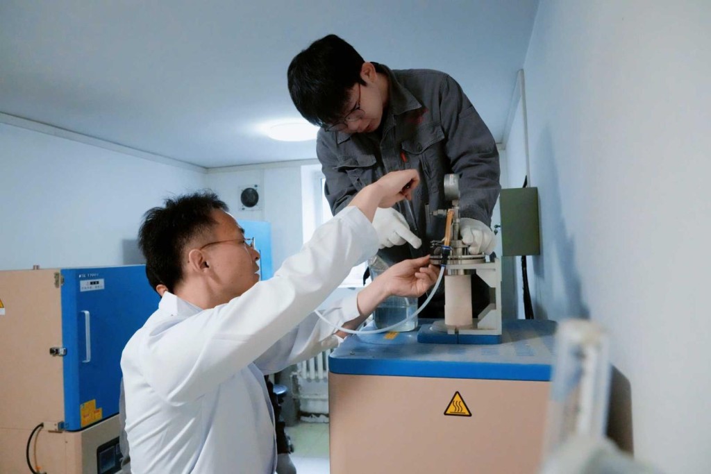 張曉東（左)興學生進行實驗機器調試。