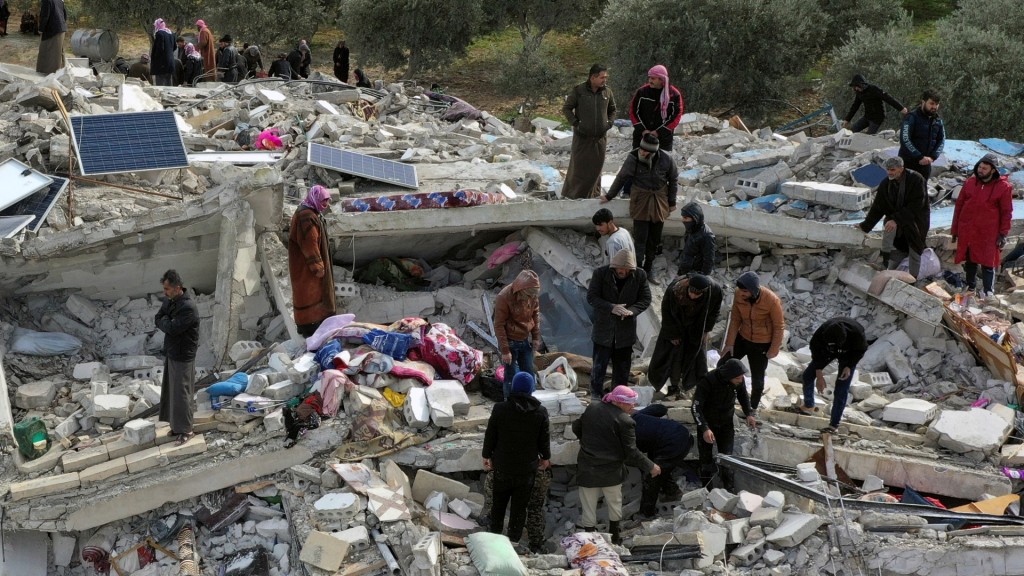 敍利亞國防軍和倖存居民在伊德利卜（Idlib）哈利姆區（Harem）的瓦礫中搜索。 美聯社
