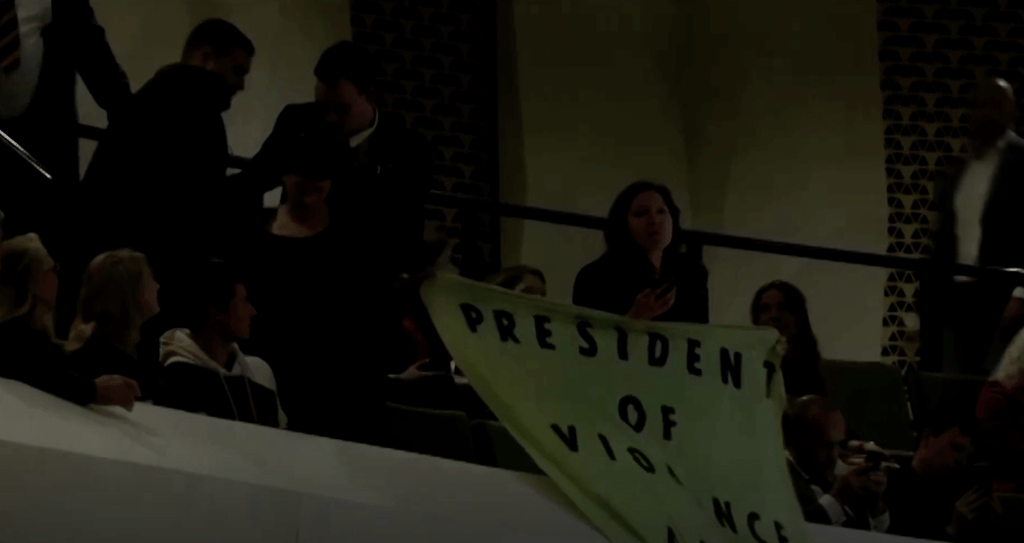 示威者展示写著「暴力和虚伪的总统」的抗议横幅。路透社影片截图