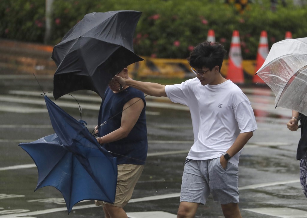 台灣台北，兩名男子撐著雨傘，抵禦颱風格美帶來的陣風。 美聯社