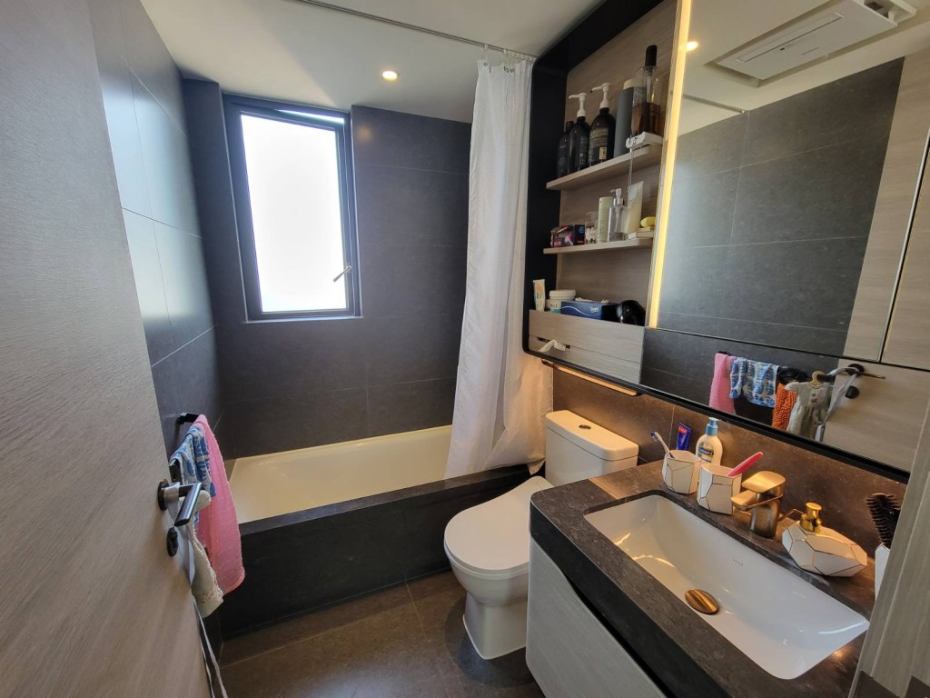 浴室以灰色为主调，配备大镜柜，并有小窗户。