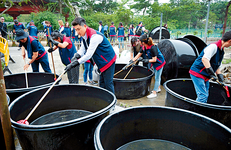 星島新聞集團行政總裁蔡晋博士與義工隊一同清洗荷花種植缸。