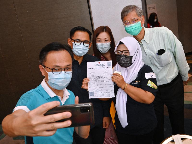 聶德權（左一）、羅致光（右一）、李吉（左二）與一名完成接種疫苗的印尼人士自拍留念。政府新聞處圖片