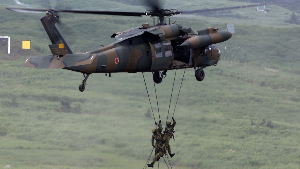 2014年日本陆上自卫队实弹演习，自卫队员从UH-60JA游绳而下。 路透社