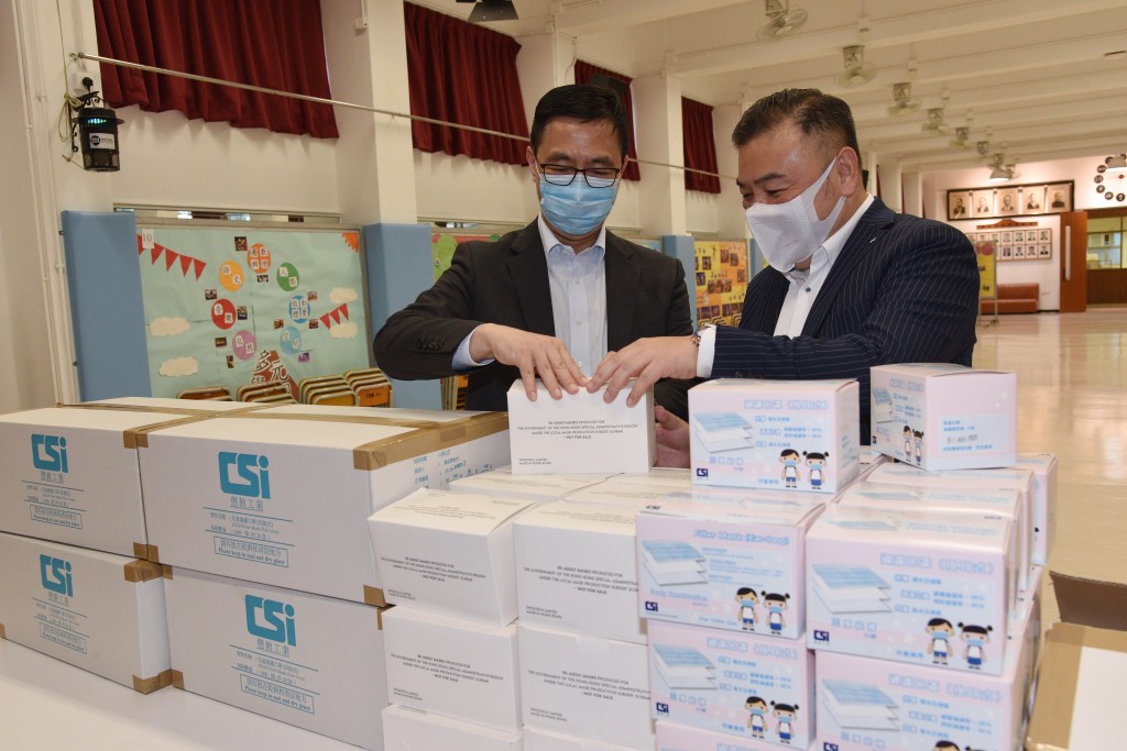 楊潤雄(左)檢視局方為全港公營及直接資助計劃中、小學提供的備用口罩。