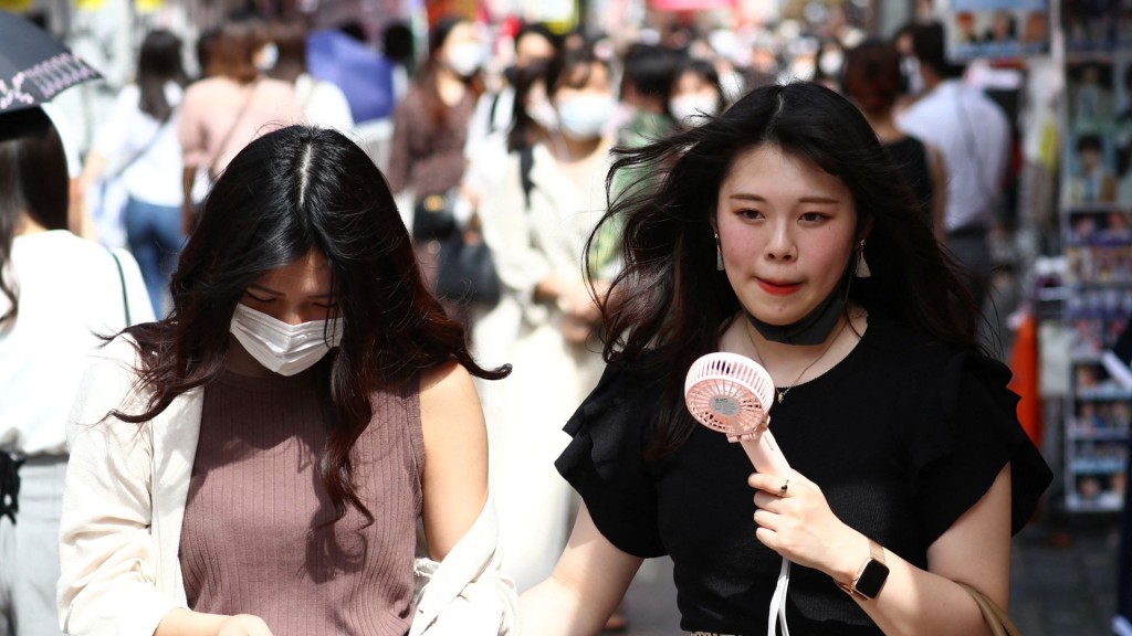 在东京涩谷区原宿的热门购物区高下通,女士们边逛街边吹小风扇降温。 法新社 在东京涩谷区原宿的热门购物区高下通,女士们边逛街边吹小风扇降温。 法新社