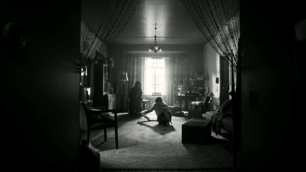 鏡頭一轉變成黑白的屋內畫面，湯唯（左）看着IU打開家中的地板。