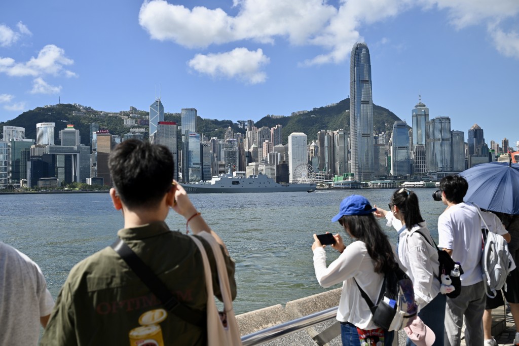 大批市民及遊客於尖東海旁舉機拍攝兩艘軍艦離港情況。劉駿軒攝