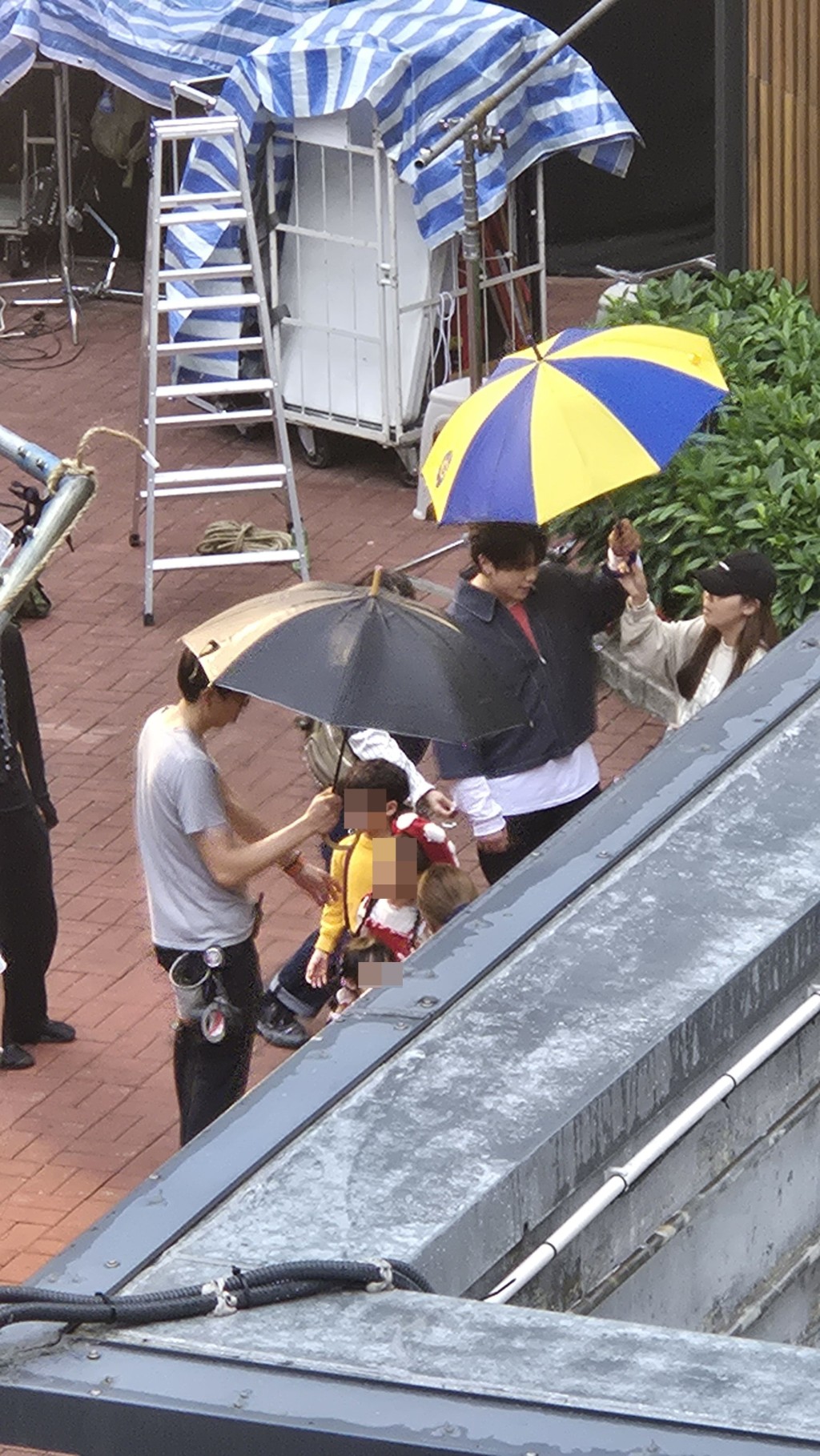拍攝當日下雨，姜濤十分親民接起工作人員遞來的雨傘，親自撐着。