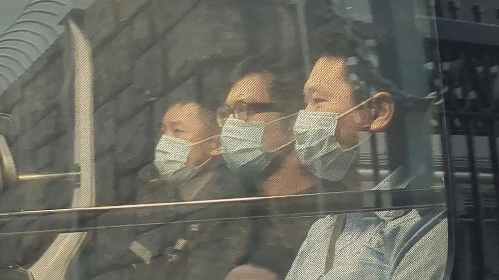 林作坐於警車後座中間。