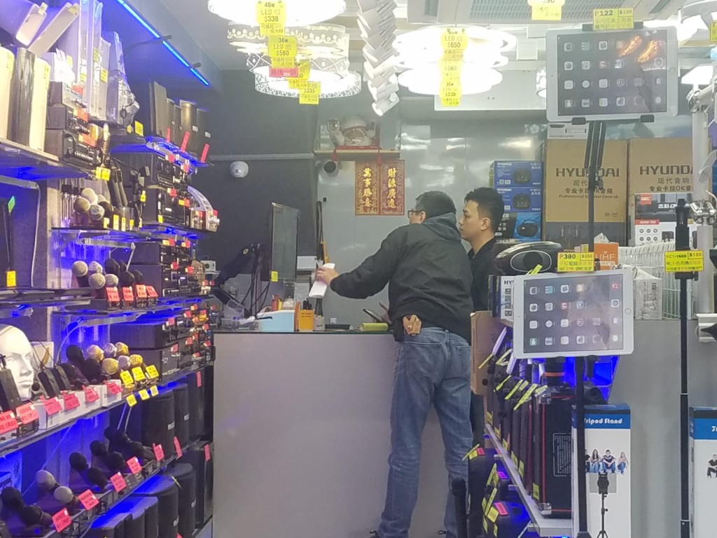 探員在案發現場附近查閱其他店鋪的閉路電視。