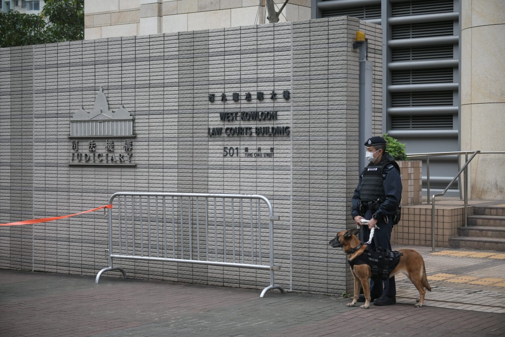 案件今早在西九龙裁判法院开审，警员携同警犬在门外站岗。陈浩元摄