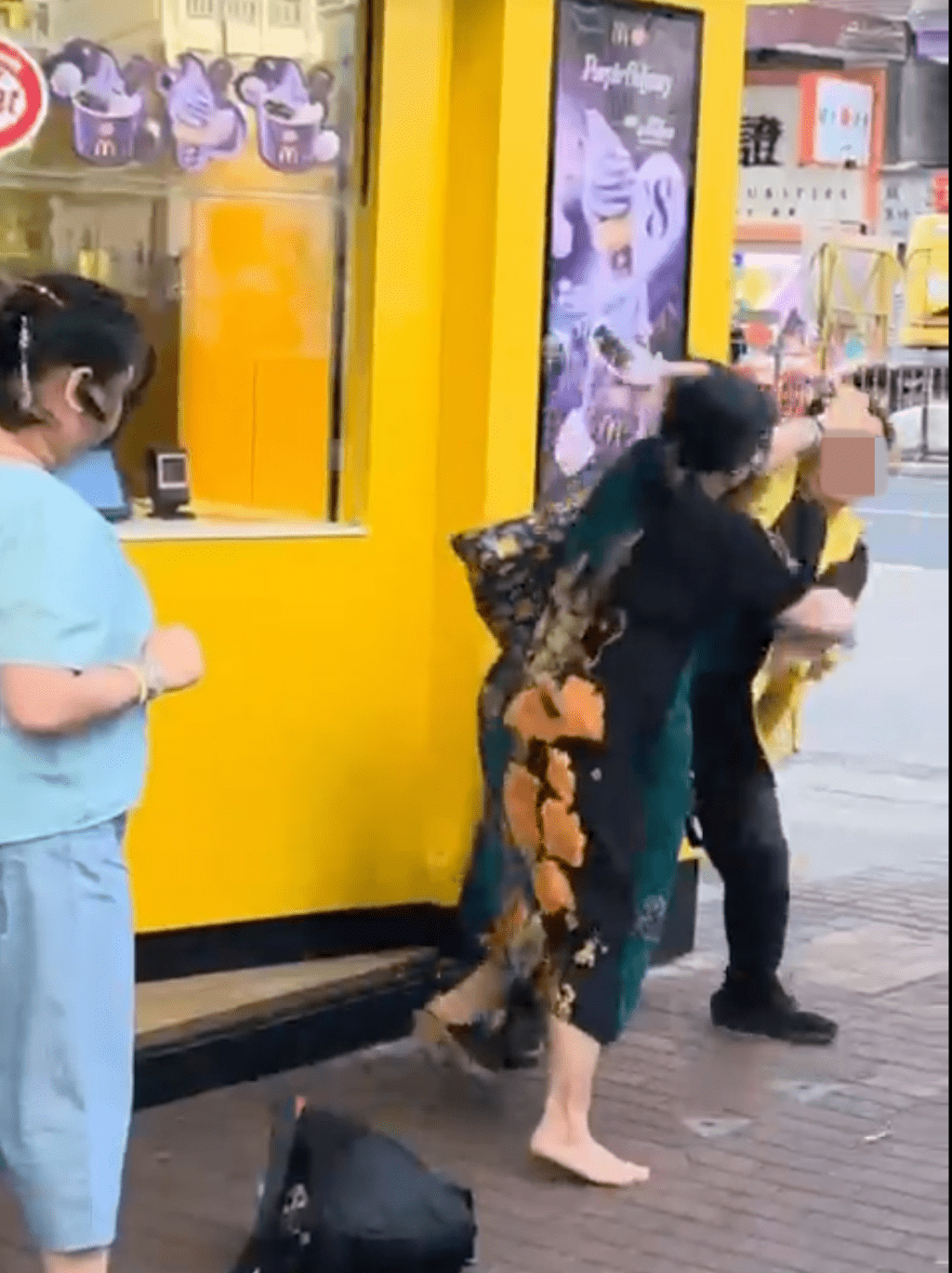 穿連身裙的女子被擊倒後，繼續上前還擊。Threads@okkelvin 影片截圖