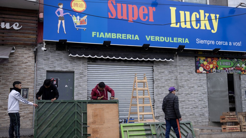 布宜诺斯艾利斯郊区一家超市受到抢劫威胁，老板在商店入口焊接加固金属门。 美联社