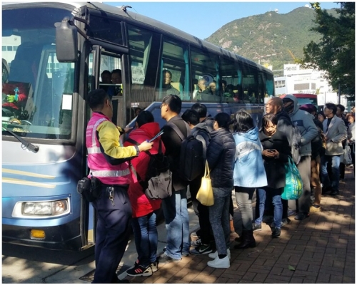 乘客排隊坐接駁車去落馬州站。歐陽偉光攝