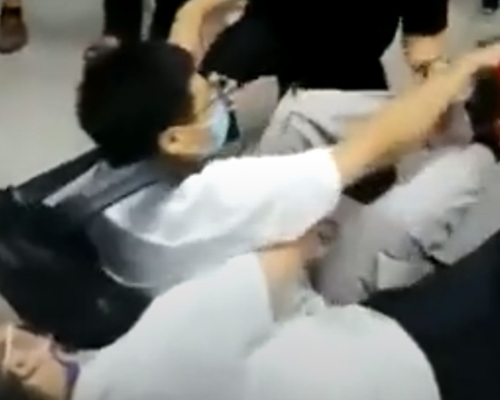 上海一名休班公安人員緊抱住懷疑偷拍男子,協助拘捕行動。影片截圖