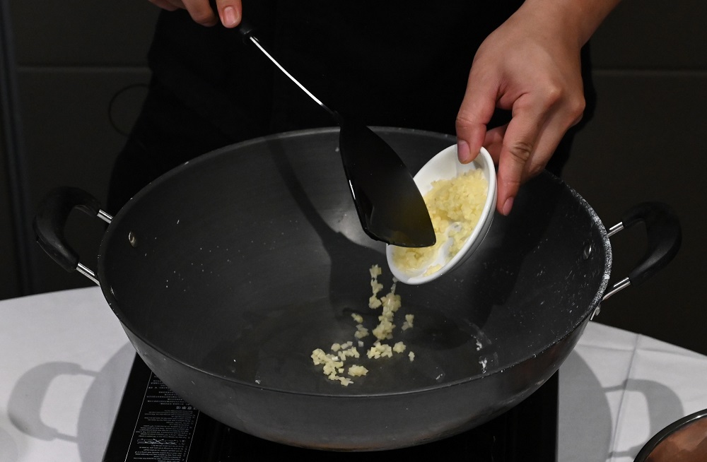4. 起油镬炒香姜米、乾葱蓉及蒜蓉。  Stir-fry the minced ginger, dried shallot and garlic with oil until fragrant in a wok.