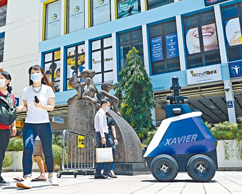 新加坡內政部科學技術局試驗機械人巡邏商場,提醒民眾在疫下保持社交距離。