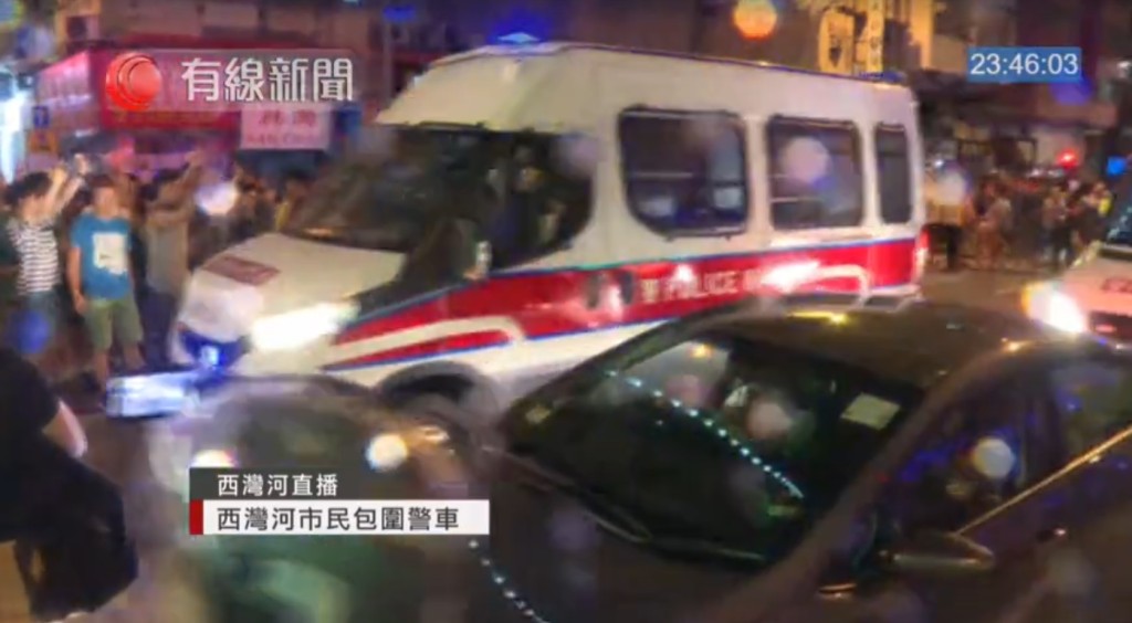 群眾西灣河包圍警車投擲雜物。有線新聞