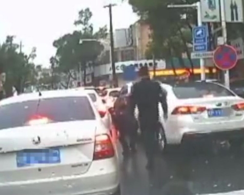 警员弯下腰捡起司机从车窗抛出的饮品胶樽，递回车内，并教训司机一顿。(网图)