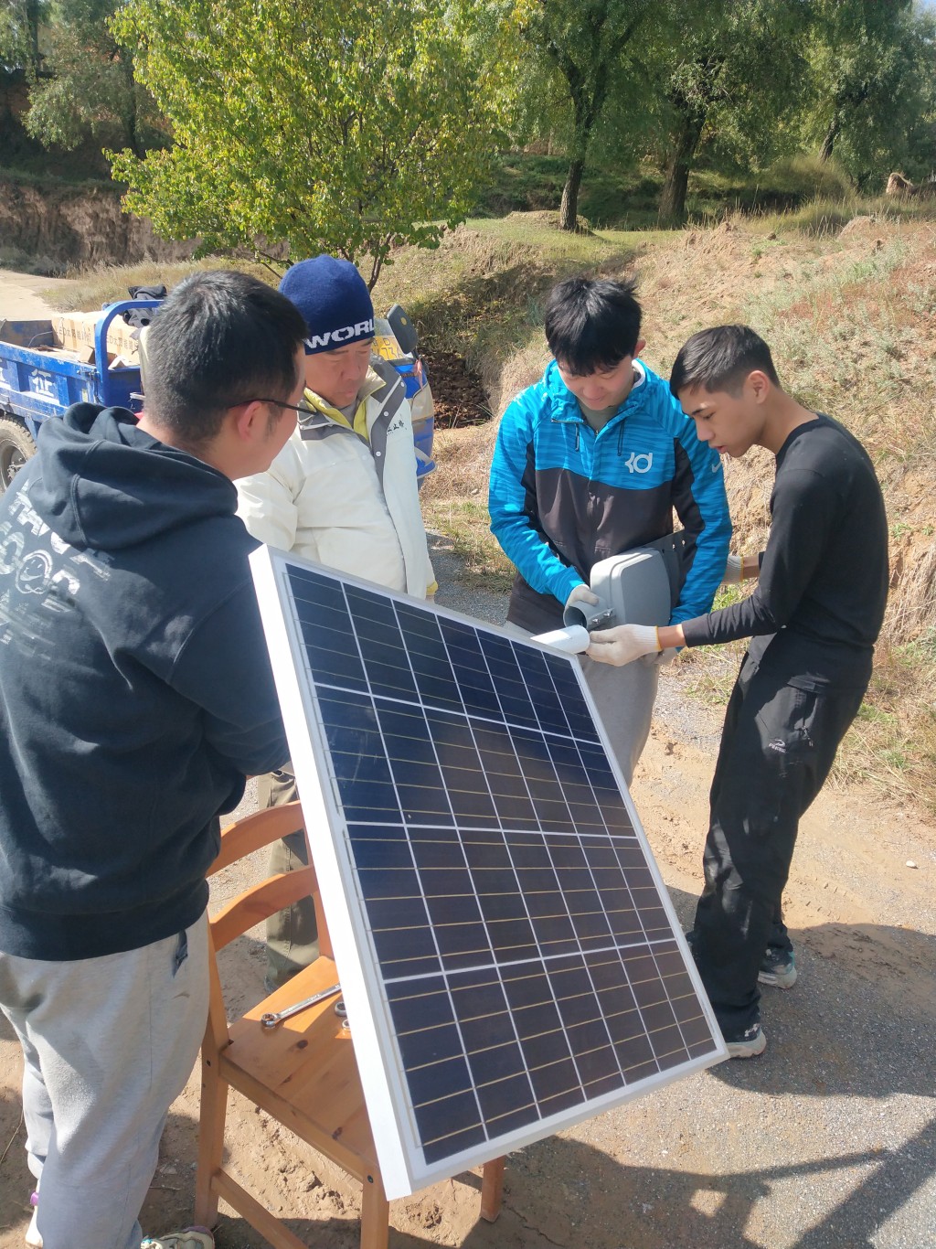 两地学生义工在甘肃马岔村开展乡村振兴工作，为村民安装太阳能路灯。