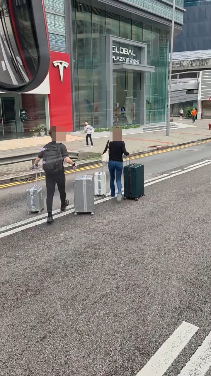 一男一女乘客拖着行李箱,橫越2條行車線到行人路。fb「車cam L(香港群組)」文迪片段截圖 一男一女乘客拖着行李箱,橫越2條行車線到行人路。fb「車cam L(香港群組)」文迪片段截圖