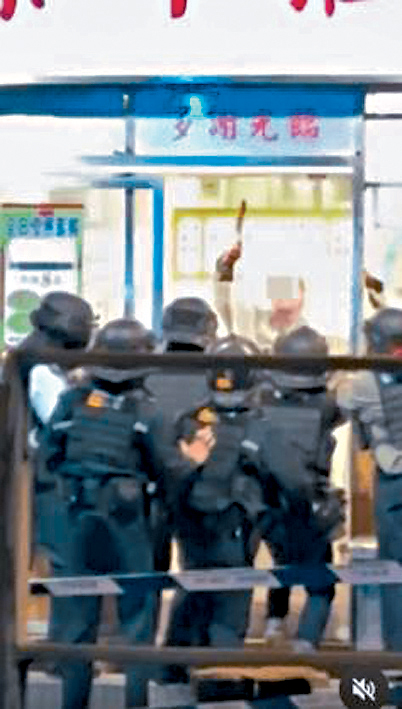 警员在店外举起盾牌对峙。