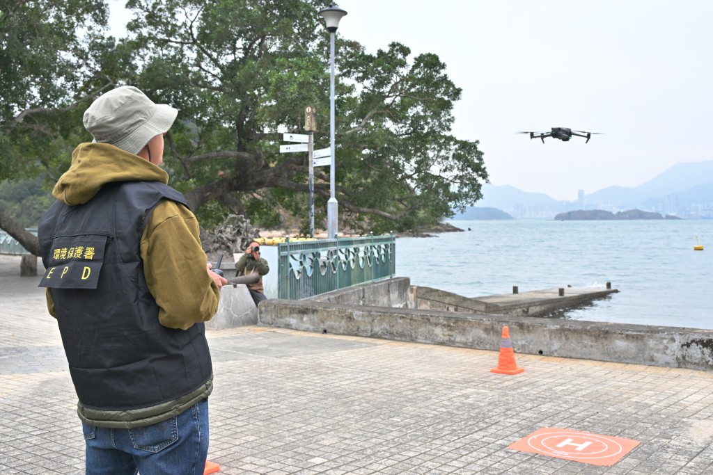 環保署人員示範，結合無人機巡查及智能監察系統，提升海岸清潔與垃圾清理效率。