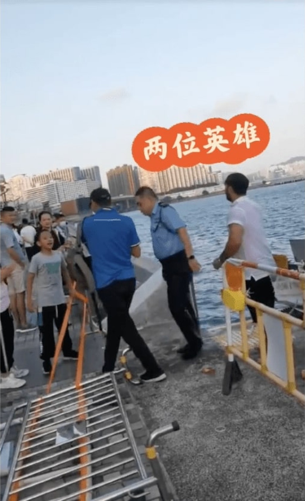 下海救人的陸海安(右二)和外籍男子(右一)上岸時獲在場市民向拍手致敬。 網上視頻截圖