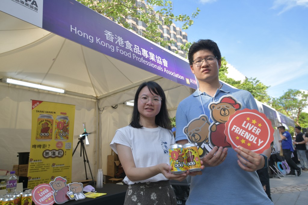 香港食品專業協會攤位負責人袁小姐（左）表示，今次活動推出本地研創的無酒精菊花啤酒。陳浩元攝
