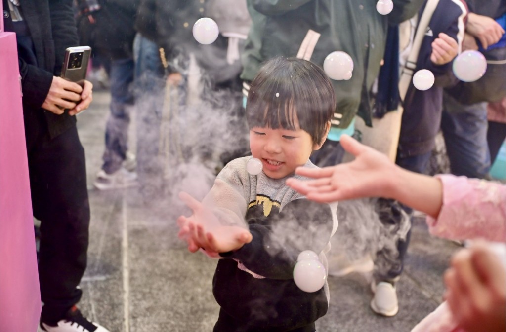 烟雾泡泡营造漫天飘雪效果，小孩笑逐颜开。