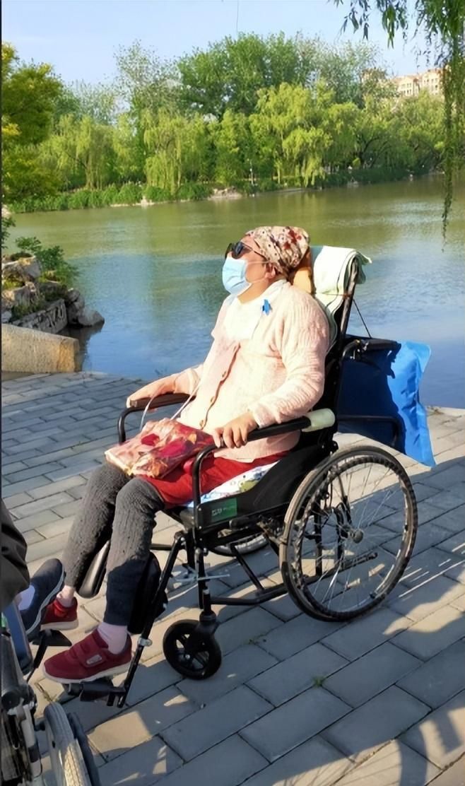 朱令坐在輪椅上在曬日光浴的近照。