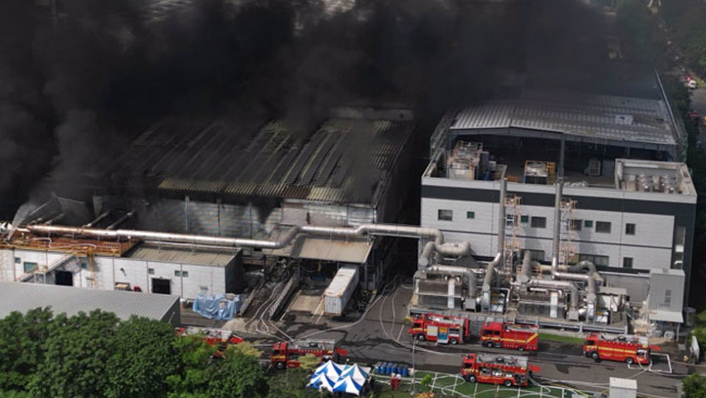 屏東科技產業園區明揚高球廠22日發生爆炸，火場23日持續悶燒，濃煙更加濃烈，一旁的廠房岌岌可危，多部消防車灌水降溫。中時