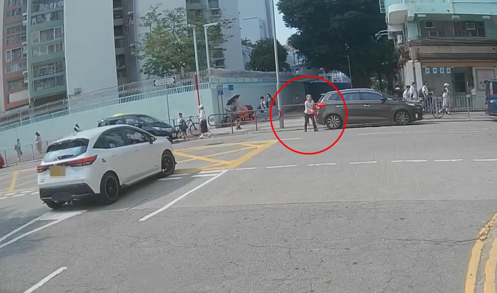 女途人手持红色胶袋，在教育路跑过对面马路。fb车cam L（香港群组）影片截图