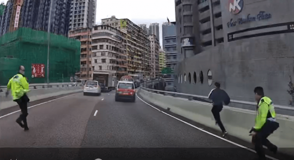 片段开首见两名军装交通警员与一名穿便服男子沿西九龙走廊往荃湾方向奔跑。网上截图 