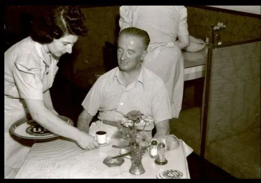 1939年，上海一間咖啡館內，服務員正為顧客端上咖啡。