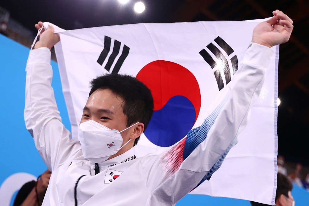 南韓選手申在煥高舉國旗。 Reuters